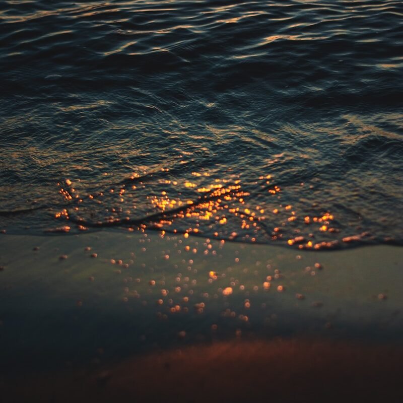 water droplets on body of water during daytime